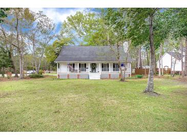 Charming single-story home featuring a cozy front porch and well-maintained lawn at 220 New Oak Ln, Moncks Corner, SC 29461