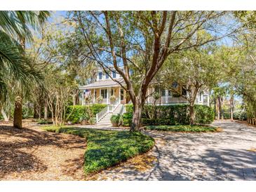Charming home featuring a welcoming porch, mature landscaping, and a grand entrance staircase at 27 Waterway Island Dr, Isle of Palms, SC 29451