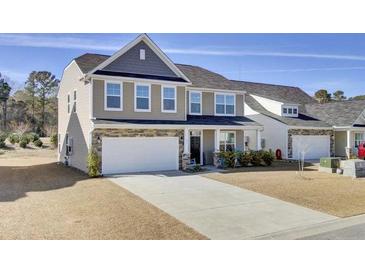 Two-story home featuring a two-car garage and a well-manicured lawn and landscaping at 307 Blue Oak Dr, Moncks Corner, SC 29461