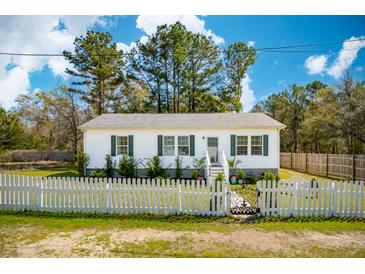 Charming single-story home with white picket fence and manicured landscaping at 5638 Dixie Plantation Rd, Hollywood, SC 29449