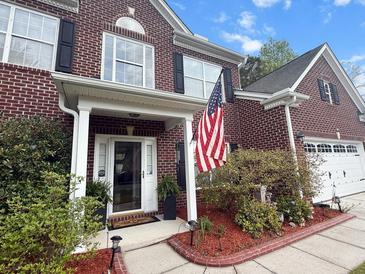 Charming brick two-story home featuring a classic front porch and a manicured front yard at 9411 Harroway Rd, Summerville, SC 29485