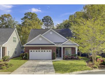Charming brick home with a well-manicured lawn, two-car garage, and lush trees at 102 Brutus Ln, Summerville, SC 29485