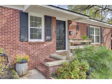 Charming brick home with a black front door, black shutters, and landscaped entrance at 1406 Iroquois St, North Charleston, SC 29405