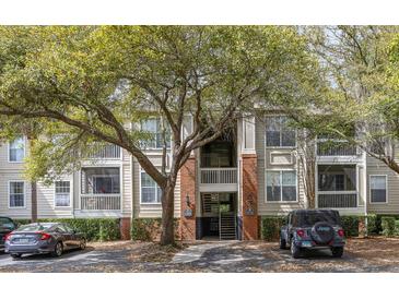 Exterior view of a multi-story apartment building with well-maintained landscaping and a tree in front at 1600 Long Grove Dr # 1226, Mount Pleasant, SC 29464