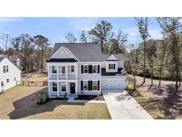 Charming two-story home features a manicured lawn, attached two-car garage, and a welcoming front porch at 3199 Great Egret Dr, Johns Island, SC 29455
