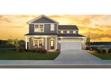 Inviting two-story home with a two-car garage, covered porch, and beautifully landscaped front yard at sunset at 5223 Cottage Landing Dr, Summerville, SC 29485