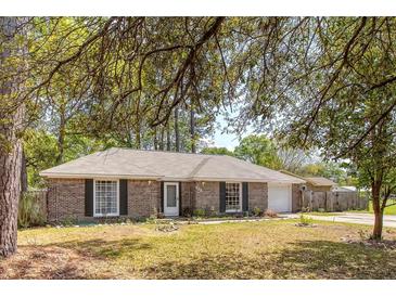 Charming one-story brick home with a well-maintained lawn and mature trees providing shade at 115 Foxborough Rd, Goose Creek, SC 29445
