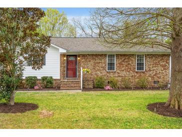 Charming single-story home with a well-maintained lawn, brick facade, and inviting red front door at 1515 Wakendaw Rd, Mount Pleasant, SC 29464
