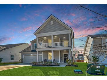 Charming two-story home featuring a welcoming front porch and manicured lawn at 185 Red Bluff St, Summerville, SC 29483