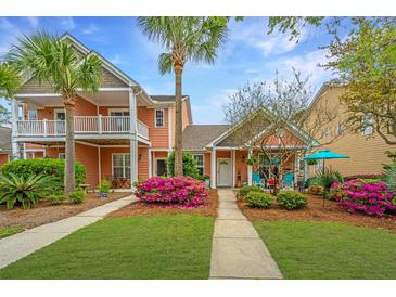 Inviting two-story home with lush landscaping, vibrant flowers, and a charming walkway leading to the front door at 2952 Sweetleaf Ln, Johns Island, SC 29455