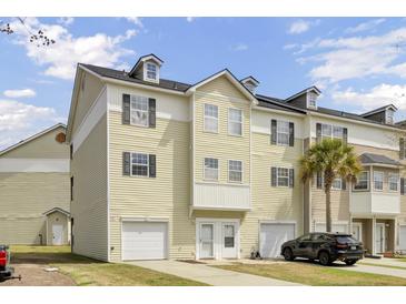 A charming townhome featuring a two car garage, dormer windows, and a well maintained yard at 4512 Great Oak Dr, North Charleston, SC 29418