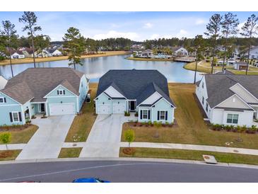 Charming light blue home featuring a three car garage and a tranquil lake view at 552 Marsh Cv Cir, Summerville, SC 29486