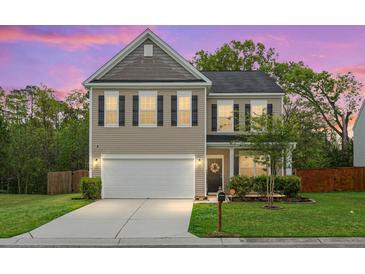 Charming two-story home featuring a well-manicured lawn, neutral siding, black shutters, and an attached two-car garage at 7818 Expedition Dr, North Charleston, SC 29420