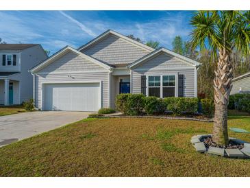 Charming single-Gathering home featuring a well-manicured front lawn and attached two-car garage at 9723 Flooded Field Dr, Ladson, SC 29456