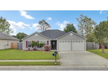 Charming single-story home featuring a well-manicured lawn, flower beds, and a two-car garage at 1302 Camden Xing, Hanahan, SC 29410