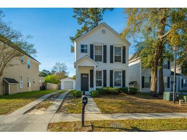 Charming two-story home featuring classic black shutters, a well-manicured lawn, and a convenient detached garage at 137 St Phillips Row, Summerville, SC 29485