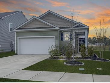 Charming single-Gathering home features manicured lawn, two car garage and craftsman style architecture at sunset at 215 Sweet Cherry Ln, Summerville, SC 29486