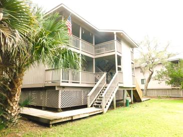 Charming multi-story house with open balconies, wooden stairs, and a well-maintained lawn at 229 Linkside Villas # 1/3 Share, Edisto Beach, SC 29438