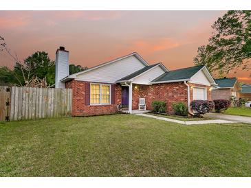 Charming single-story brick home featuring a well-manicured lawn and cozy front porch at sunset at 234 Two Hitch Rd, Goose Creek, SC 29445
