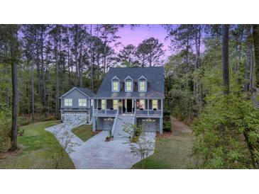 Charming two-story home with a double garage and welcoming front porch nestled among tall trees at 2856 Claybrook St, Johns Island, SC 29455