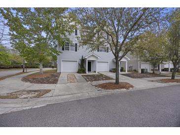 Charming townhome featuring light gray siding, a one-car garage, and a well-manicured lawn with mature trees at 4120 Veritas St, Charleston, SC 29414