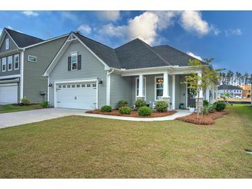 Charming single-Gathering home featuring a manicured lawn, attached garage, and a welcoming front porch at 603 Dunswell Dr, Summerville, SC 29486