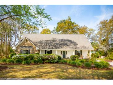 Charming single-story home with a lush landscaped yard and blooming azaleas at 630 Cain Dr, Mount Pleasant, SC 29464