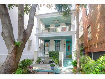 Charming two-story home with a double porch, painted in cool white and accented with turquoise trim at 78 Society St, Charleston, SC 29401