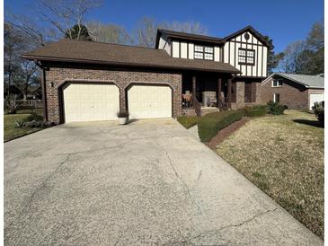 Charming brick home with a two-car garage and Tudor-style accents on a sunny day at 8147 Waltham Rd, North Charleston, SC 29406