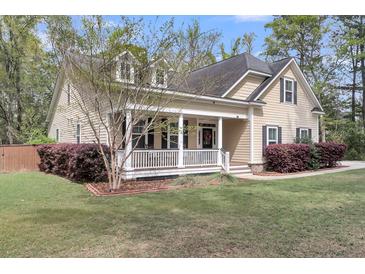 Charming home with a welcoming front porch, manicured lawn, and fresh landscaping at 8618 Mcchune Ct, North Charleston, SC 29420