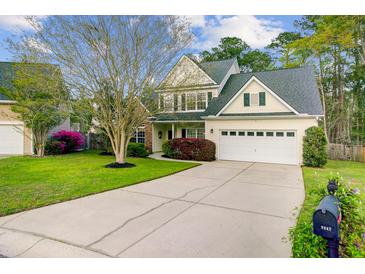 Charming two-story home with a well-manicured lawn, mature trees, and a spacious driveway at 9447 Harroway Rd, Summerville, SC 29485
