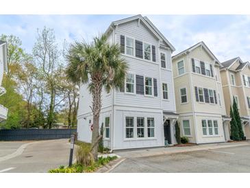 Charming three-story home with white siding, black shutters, and a well-maintained yard at 975 Warrick Oaks Ln, Mount Pleasant, SC 29464