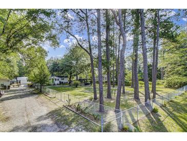Landscaped yard featuring a white home, a privacy fence, and a canopy at 130 Oak Crest Dr, Moncks Corner, SC 29461
