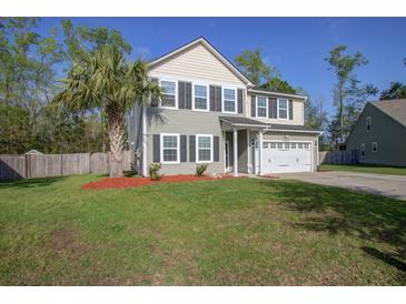 Charming two-story home featuring a manicured lawn, two car garage, and beautiful landscaping at 1909 Royal Empress Ct, Charleston, SC 29414