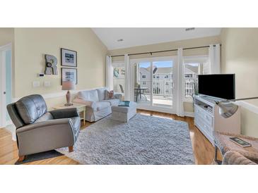 Cozy living room with lots of seating, white accents, and a view of the outdoor balcony at 1984 Folly Rd # A306, Charleston, SC 29412