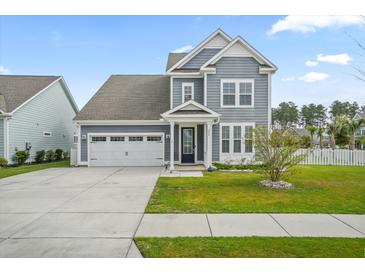 Charming home featuring a well-maintained lawn, a two car garage, and light blue siding at 204 Corvus St, Summerville, SC 29483