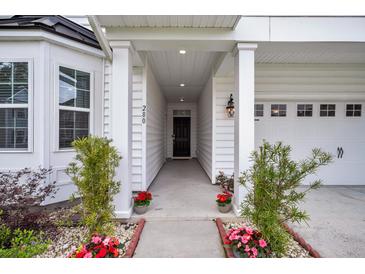 Inviting front entrance featuring a covered porch, white columns, and meticulously arranged potted flowers at 280 Swamp Creek Ln, Moncks Corner, SC 29461