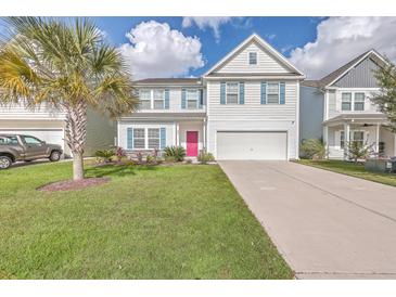 Charming two-story home featuring a well-manicured lawn, a palm tree, and a striking pink front door at 353 Dunlin Dr, Summerville, SC 29486