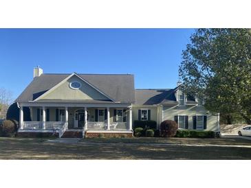 Charming home featuring a welcoming front porch, well-maintained lawn and mature landscaping at 527 W Butternut Rd, Summerville, SC 29483