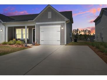 Charming home featuring a spacious driveway and a white garage door, set against a beautiful sunset at 832 Descartes St, Summerville, SC 29486