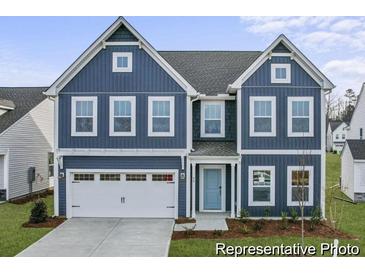 Charming two-story home featuring a blue exterior, a white garage door, and a well-manicured front lawn at 1005 Toland Dr # 44P, Saint George, SC 29477