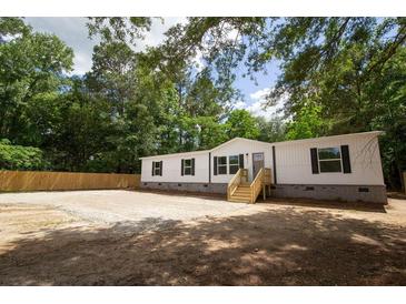 Charming single-story home featuring white siding, black shutters, and a welcoming wood staircase to the front door at 1030 Merell Ave, Bonneau, SC 29431