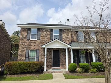 Charming brick townhouse with a covered front porch and manicured landscaping at 108 Sandlewood Dr, Summerville, SC 29483