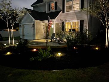 Charming two-story home featuring a front yard with landscaped lighting and comfortable seating area at 1414 N Sherwood Dr, Charleston, SC 29407