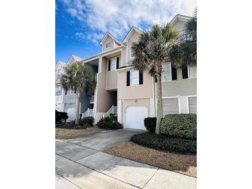 Inviting townhome exterior with a one car garage, complemented by lush landscaping and palm trees at 155 Winding River Dr, Johns Island, SC 29455
