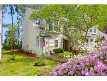 Charming two-story home with an inviting front porch and beautifully landscaped front yard with pink and white flowers at 2 Townpark Ln # D, Charleston, SC 29412