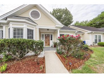 Charming one-story home featuring a well-manicured yard, covered porch, and a welcoming entrance at 2441 Hansard Dr, North Charleston, SC 29406
