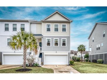 Inviting two-story townhome with a ground-level garage and a charming palm tree in the front yard at 307 Lanyard St, Johns Island, SC 29455