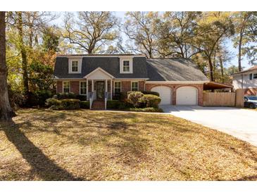Charming brick home with a welcoming front porch, dormer windows, mature trees and a two-car attached garage at 643 Edmonds Dr, Charleston, SC 29412