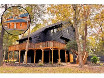 Stunning dark home exterior with a large wraparound deck and complementing natural wood staircase at 6464 St Anthony Dr, Hollywood, SC 29449